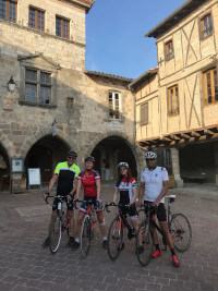 Four cyclists in the centre of Castelnau de Montmiral.